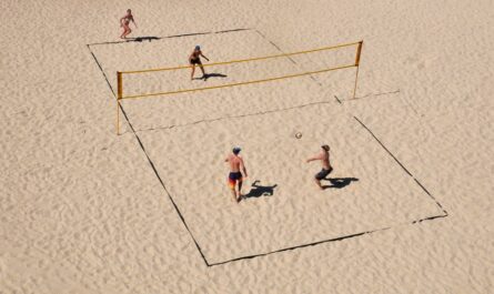 Spēlētāju grupa, kas izmanto pludmales volejbola inventāru.