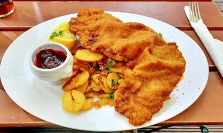 Wiener schnitzel with potatoes served on a plate.